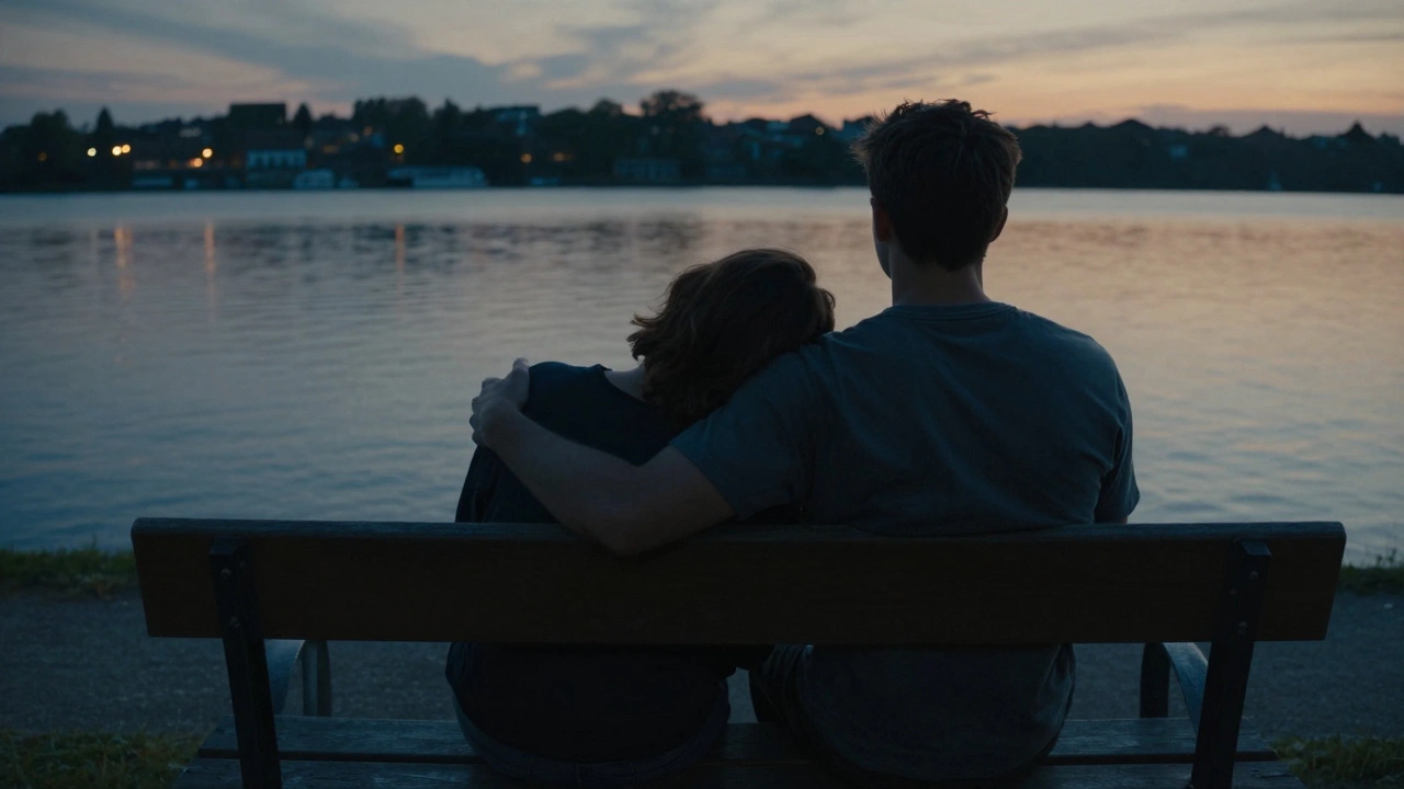 Twee mensen zitten stil op een bank bij een rivier bij zonsondergang, zonder telefoons, in een moment van verbinding.