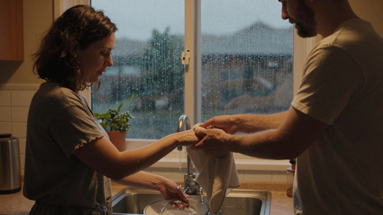 Een man reikt zijn partner een handdoek aan in de keuken, hun vingers raken elkaar even.
