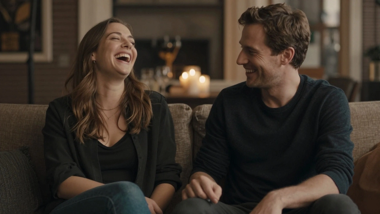 Een man en vrouw zitten naast elkaar, lachend, met ogen naar elkaar gericht, op een bank in een gezellige setting.