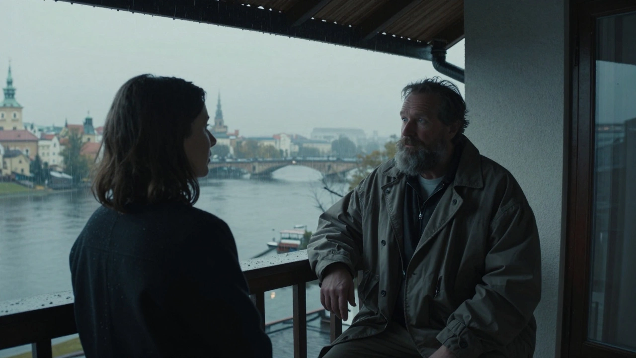 Een man met baard en losse kleren kijkt naar een vrouw terwijl regen op het dak valt in Praag.