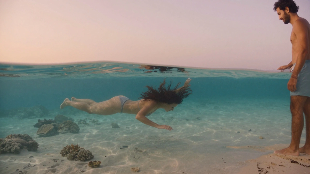 Een vrouw drijft in een ongerepte lagune bij zonsopgang, haar haar zwevend in het water, terwijl haar partner vanaf de kust kijkt.